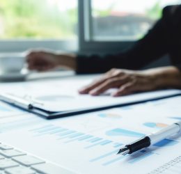 Asian business woman analyzing investment charts on desk. Vintage tone Retro filter effect,soft focus,low light.(selective focus).
